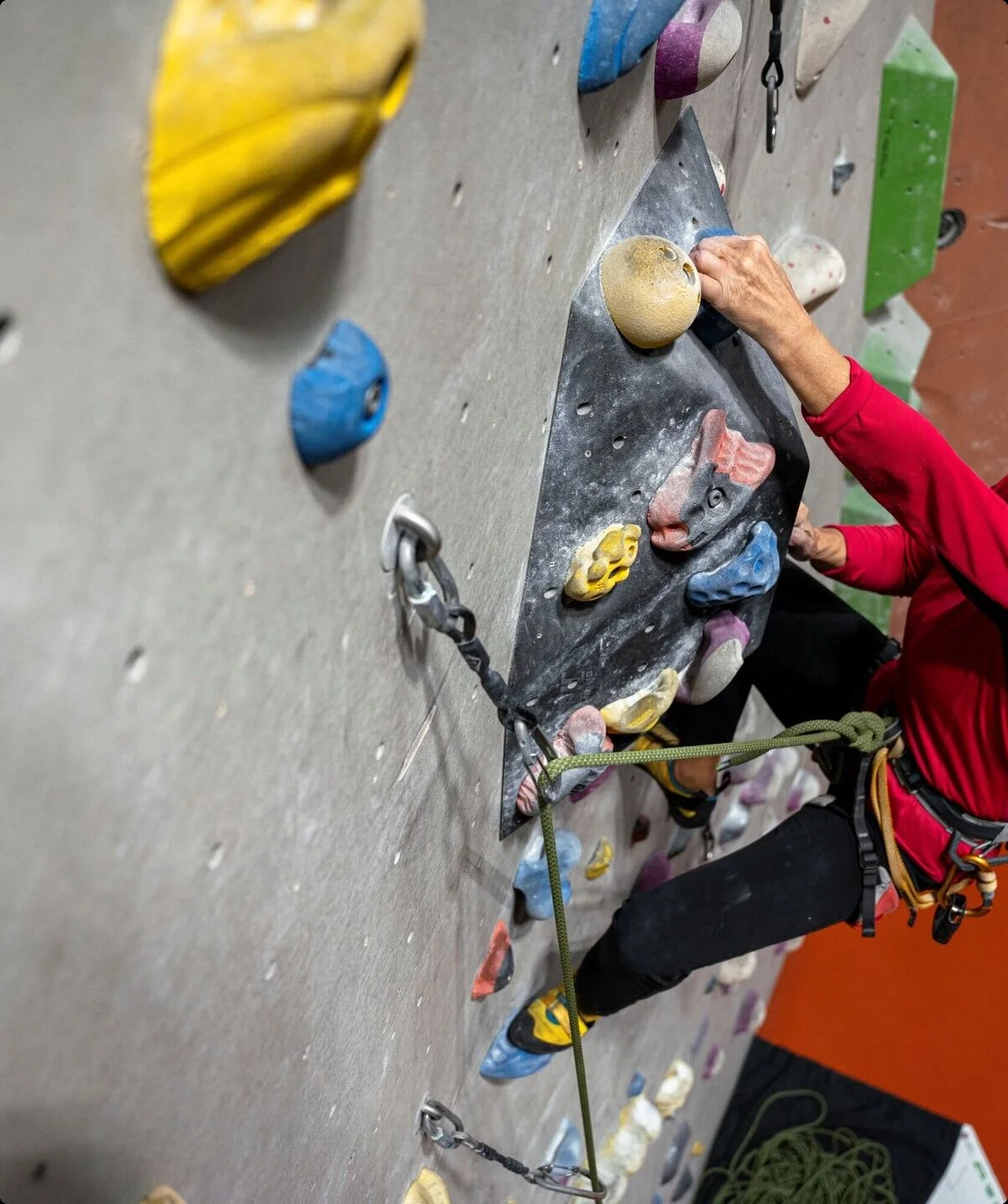 Eine Frau klettert gesichert an einer Boulderwand | © DAV / Julian Rohn