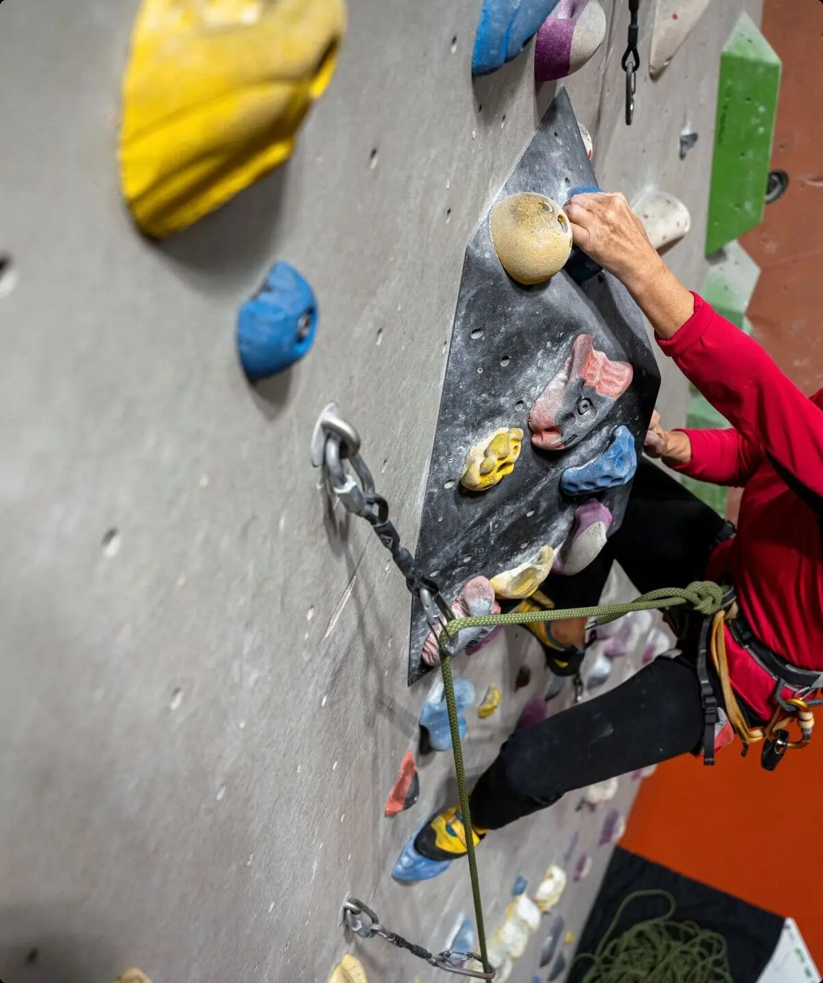 Eine Frau klettert gesichert an einer Boulderwand | © DAV / Julian Rohn