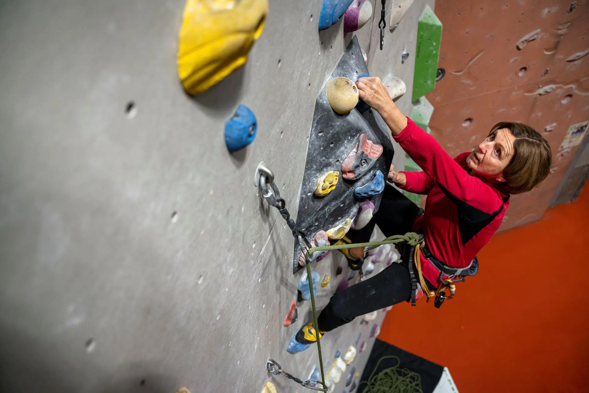Eine Frau klettert gesichert an einer Boulderwand | © DAV / Julian Rohn