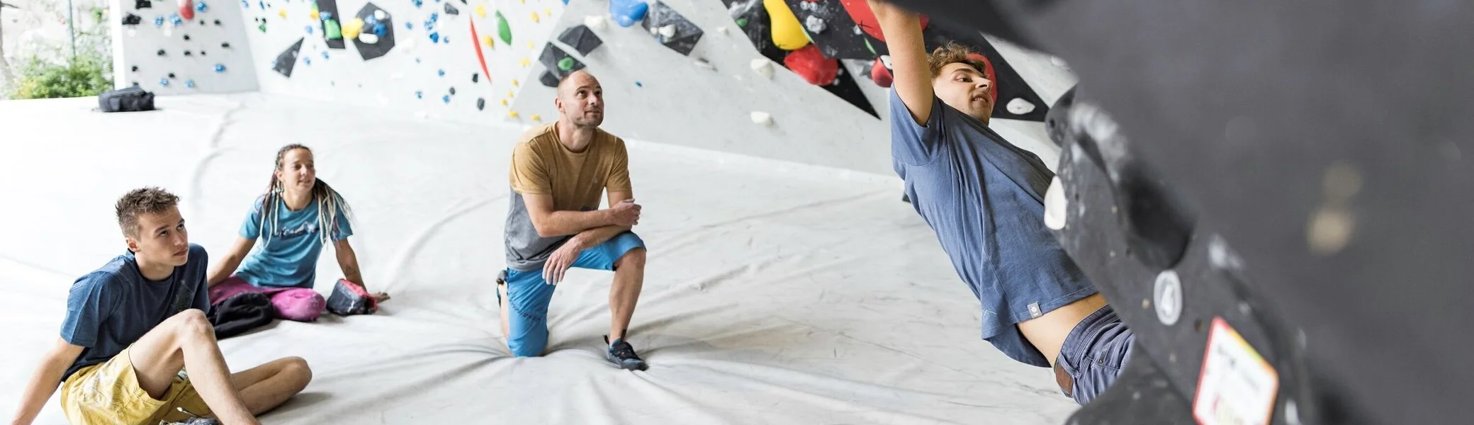 Ein Mann beim Bouldern, im Hintergrund warten weitere Personen, bis sie an der Reihe sind | © DAV / Jens Klatt