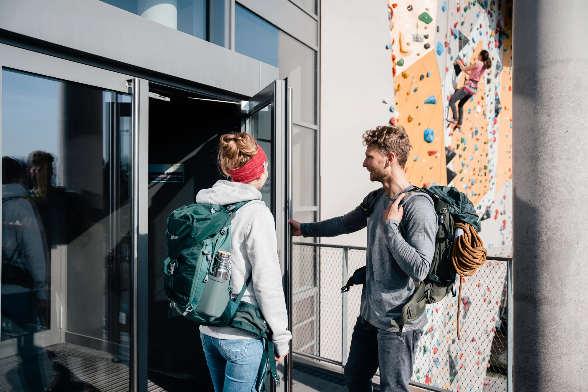 Zwei Persinen öffnen die Tür zu einer Boulder- und Kletterhalle | © DAV/Marisa Koch