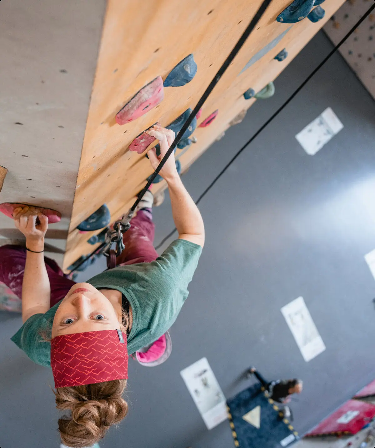 Eine Frau klettert in einer Kletterhalle, ihr Partner sichert sie. | © DAV/Marisa Koch