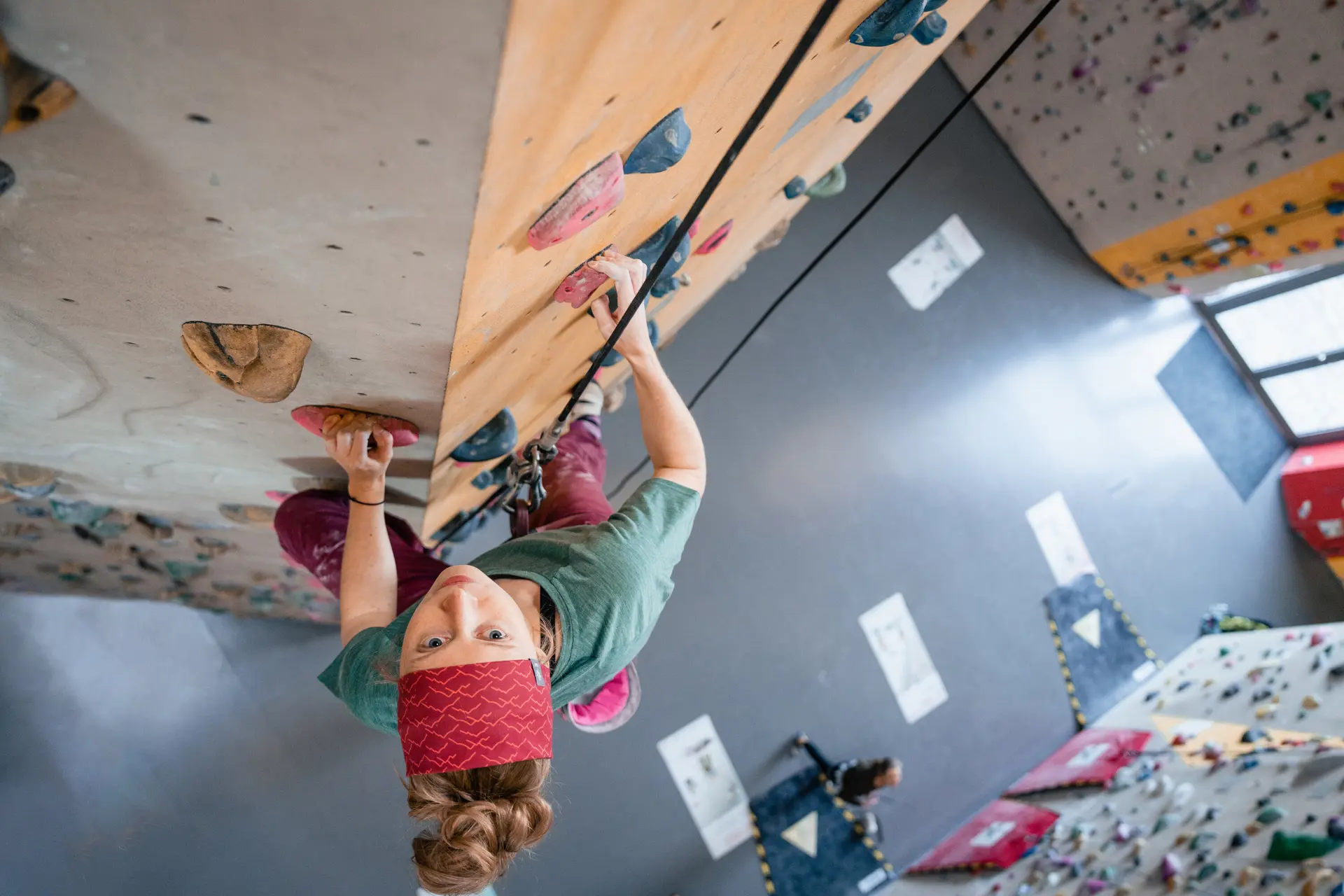 Eine Frau klettert in einer Kletterhalle, ihr Partner sichert sie. | © DAV/Marisa Koch
