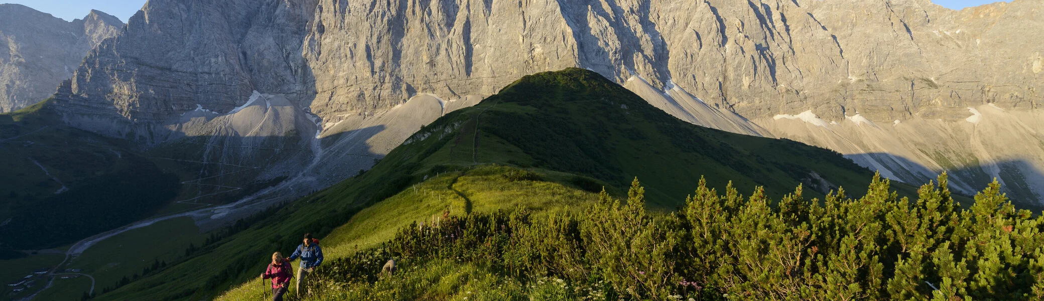 Panoramaaufname von Berggipfeln mit zwei Wanderern | © DAV/Wolfgang Ehn